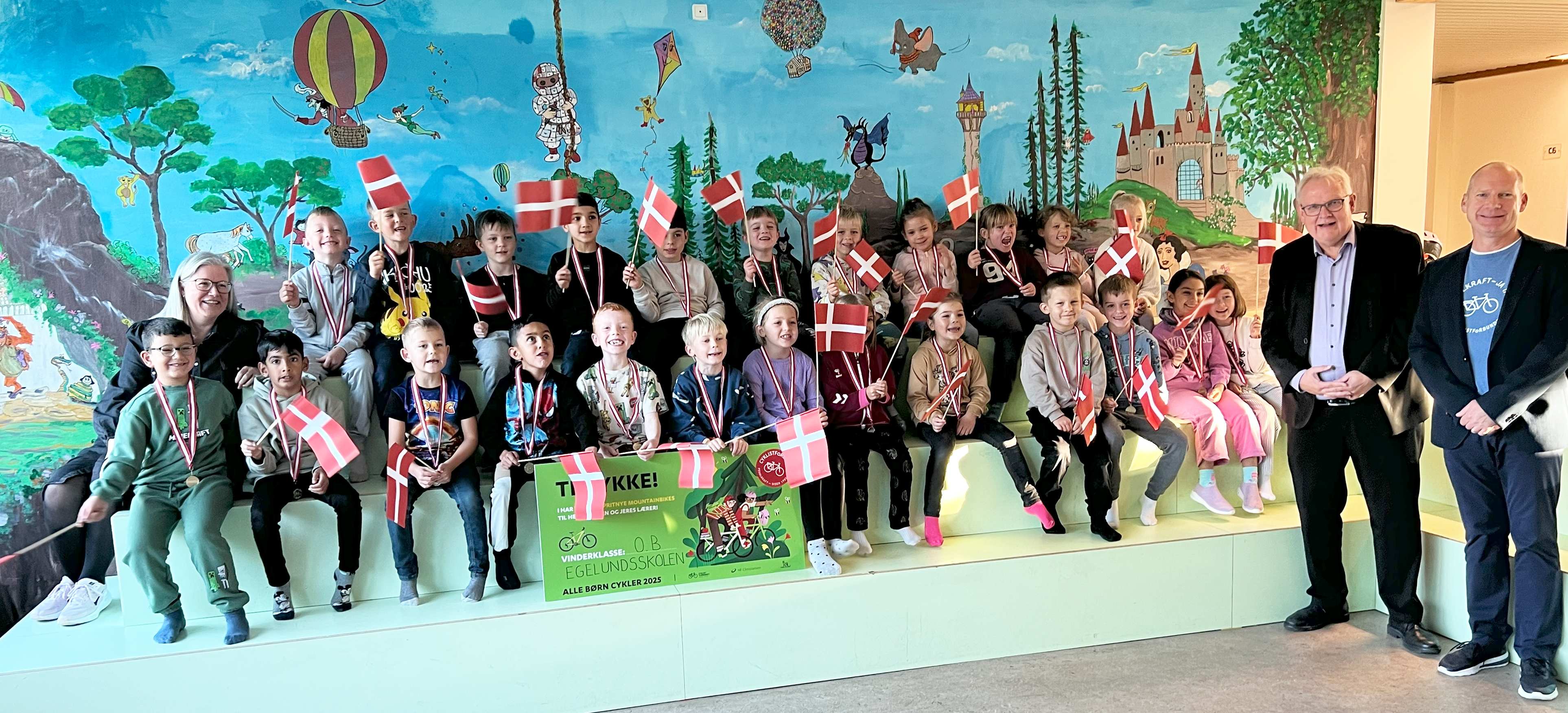 Vinderne af Alle Børn Cykler 2025: 0.B på Egelundskolen i Albertslund sammen med borgmester Steen Christiansen og Cyklistforbundets direktør, Kenneth Øhrberg Krag, der overbragte det glade budskab.